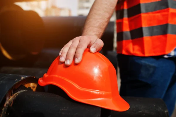hand-worker-man-safety-orange-helmet-near-steel-pipes_627829